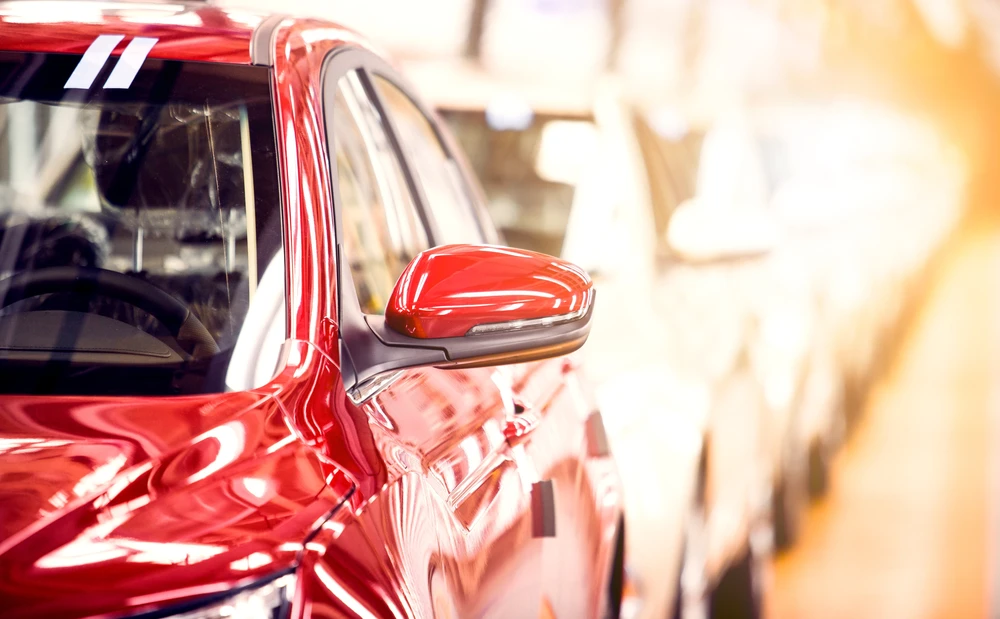 Scène extérieure d'un concessionnaire automobile avec véhicules rouges garés