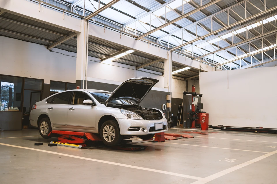 Atelier de mécanique automobile, véhicule sur pont élévateur